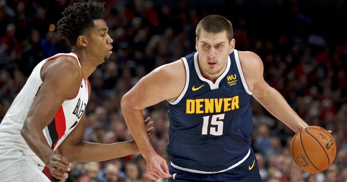Denver Nuggets center Nikola Jokic dribbles past Portland Trail Blazers center Hassan Whiteside during the first half of an NBA basketball game in Portland, Ore., Wednesday, Oct. 23, 2019. (AP Photo/Craig Mitchelldyer)