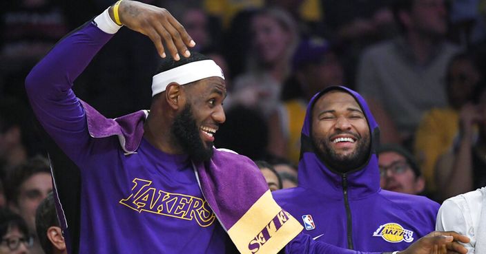Los Angeles Lakers forward LeBron James, left, jokes around with center DeMarcus Cousins on the bench during the second half of the team's preseason NBA basketball game against the Golden State Warriors on Wednesday, Oct. 16, 2019, in Los Angeles. The Lakers won 126-93. (AP Photo/Mark J. Terrill)