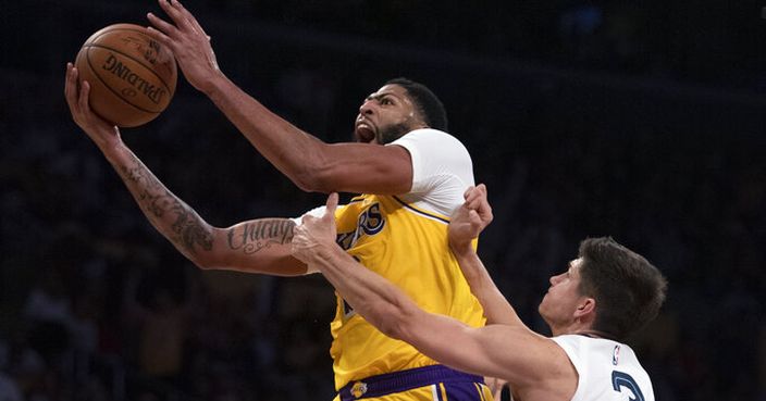 Los Angeles Lakers forward Anthony Davis, left, leaps for a basket next to Memphis Grizzlies guard Grayson Allen during the second half of an NBA basketball game in Los Angeles, Tuesday, Oct. 29, 2019. (AP Photo/Kyusung Gong)