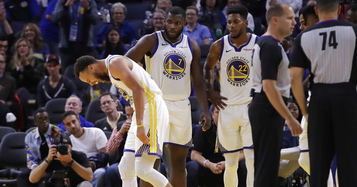 Golden State Warriors' Stephen Curry, left, grimaces after Phoenix Suns' Aron Baynes fell onto him during the second half of an NBA basketball game Wednesday, Oct. 30, 2019, in San Francisco. Curry left the game. (AP Photo/Ben Margot)