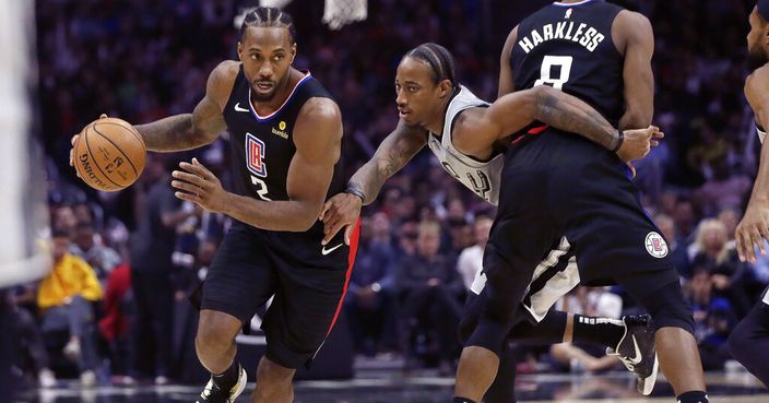 San Antonio Spurs guard DeMar DeRozan, center, battles his way around a pick by Los Angeles Clippers forward Maurice Harkless, right, as forward Kawhi Leonard, left, drives with the ball during the second half of an NBA basketball game in Los Angeles, Thursday, Oct. 31, 2019. (AP Photo/Alex Gallardo)