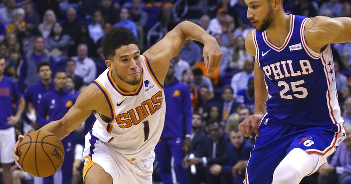 Phoenix Suns guard Devin Booker (1) drives past Philadelphia 76ers guard Ben Simmons (25) during the second half of an NBA basketball game, Monday, Nov. 4, 2019, in Phoenix. The Suns defeated the 76ers 114-109. (AP Photo/Ross D. Franklin)
