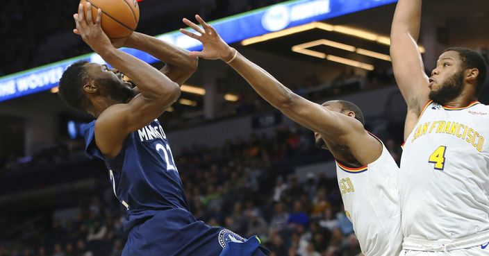 Minnesota Timberwolves' Andrew Wiggins, left, drives the basket as Golden State Warriors' Omari Spellman, right, and Alec Burks defend in the first half of an NBA basketball game Friday, Nov 8, 2019, in Minneapolis. (AP Photo/Jim Mone)