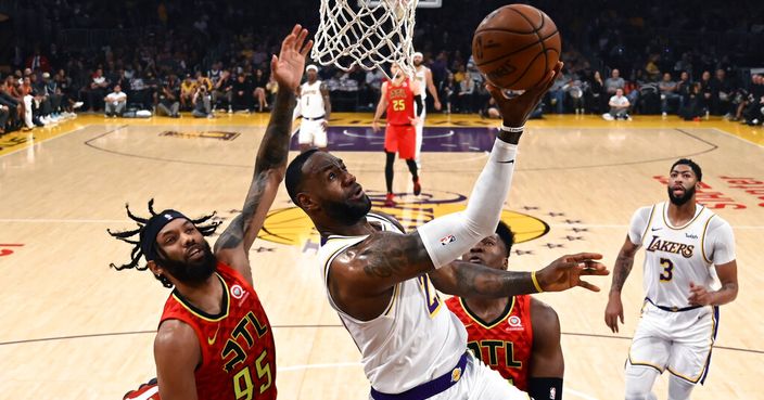 Los Angeles Lakers' LeBron James (23) shoots under pressure from Atlanta Hawks' DeAndre' Bembry during the first half of an NBA basketball game, Sunday, Nov. 17, 2019, in Los Angeles. (AP Photo/Ringo H.W. Chiu)