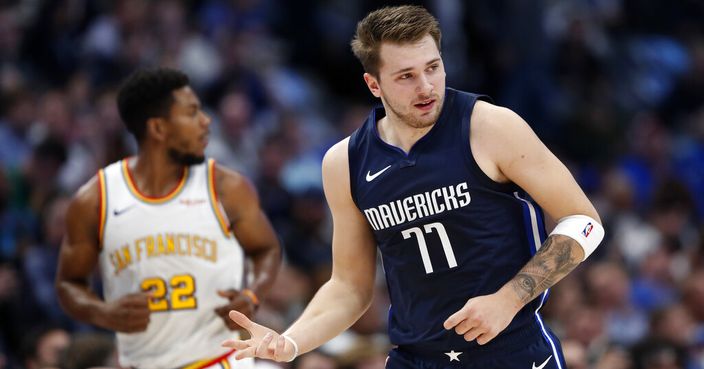 Dallas Mavericks forward Luka Doncic (77) celebrates sinking a 3-point basket as Golden State Warriors forward Glenn Robinson III (22) follows behind in the first half of an NBA basketball game in Dallas, Wednesday, Nov. 20, 2019. (AP Photo/Tony Gutierrez)