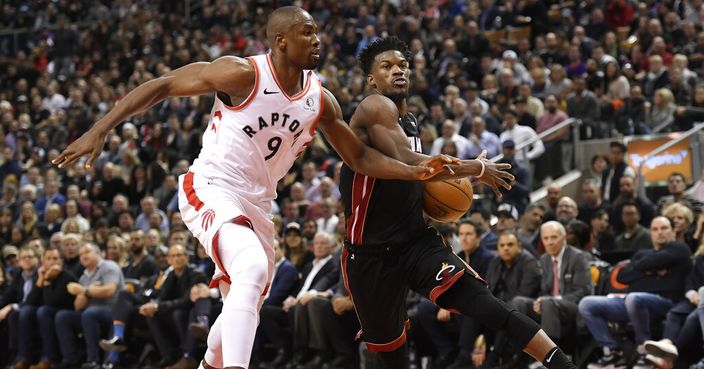 Miami Heat forward Jimmy Butler (22) drives past Toronto Raptors forward Serge Ibaka (9) during the second half of an NBA basketball game Tuesday, Dec. 3, 2019, in Toronto. (Nathan Denette/The Canadian Press via AP)