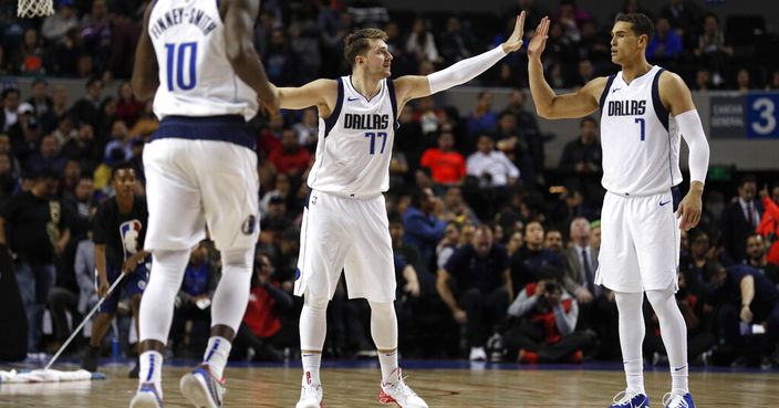 Dallas Mavericks' Luka Doncic, center, is congratulated by his teammate Dwight Powell, right, in the second half of their regular-season NBA basketball game in Mexico City, Thursday, Dec. 12, 2019. (AP Photo/Rebecca Blackwell)