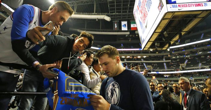 Dallas Mavericks' Luka Doncic, center, signs autographs for fans prior to a regular-season NBA basketball game against Detroit Pistons in Mexico City, Thursday, Dec. 12, 2019. (AP Photo/Rebecca Blackwell)