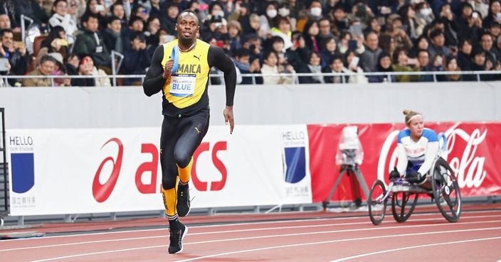 In this photo provided by Japan Sports Council (JSC), Olympics gold medalist Usain Bolt, left, of Jamaica runs at the opening ceremony of the New National Stadium, the main venue for the Tokyo 2020 Olympic and Paralympic Games, in Tokyo, Japan, Saturday, Dec. 21, 2019. (JSC via AP)