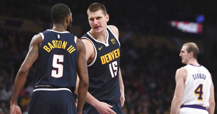 Denver Nuggets center Nikola Jokic (15) talks with forward Will Barton III (5) after Jokic was fouled during the second half of an NBA basketball game against the Los Angeles Lakers Sunday, Dec. 22, 2019, in Los Angeles. The Nuggets won 128-104. (AP Photo/Michael Owen Baker)
