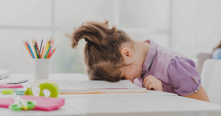 Lazy student girl at home, she is resting with her face down on the school book, education and childhood concept