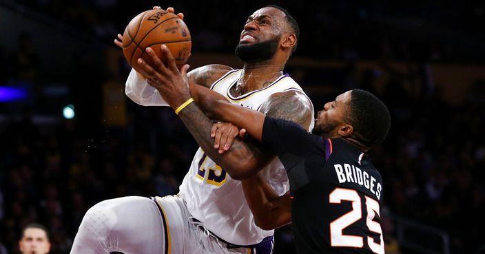 Los Angeles Lakers' LeBron James (23) is fouled by Phoenix Suns' Mikal Bridges (25) during the second half of an NBA basketball game Wednesday, Jan. 1, 2020, in Los Angeles. The Lakers won 117-107. (AP Photo/Ringo H.W. Chiu)