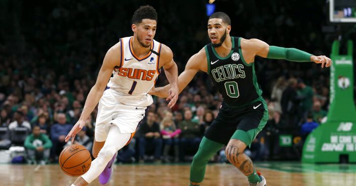 Phoenix Suns guard Devin Booker (1) drives past Boston Celtics forward Jayson Tatum (0) during the first half of an NBA basketball game, Saturday, Jan. 18, 2020, in Boston. (AP Photo/Mary Schwalm)