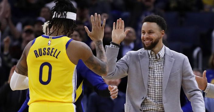Golden State Warriors' Stephen Curry, right, congratulates D'Angelo Russell (0) during a timeout in the second half of the team's NBA basketball game against the Orlando Magic on Saturday, Jan. 18, 2020, in San Francisco. (AP Photo/Ben Margot)