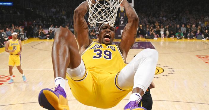 Los Angeles Lakers center Dwight Howard hangs on the basket as he dunks during the first half of an NBA basketball game against the Cleveland Cavaliers Monday, Jan. 13, 2020, in Los Angeles. (AP Photo/Mark J. Terrill)