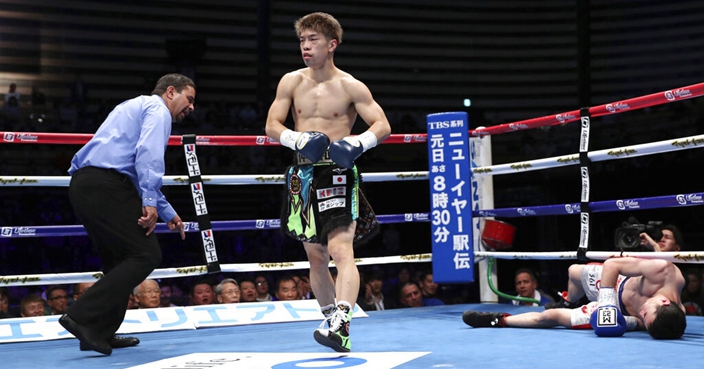 Japanese champion Kosei Tanaka, center, returns to his corner after knocking down Chinese challenger Wulan Tuolehazi in the third round of their WBO flyweight world boxing title match in Tokyo, Tuesday, Dec. 31, 2019. Tanaka defended his title after knocking out Wulan in the round. (AP Photo/Toru Takahashi)