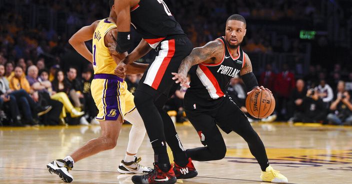 Portland Trail Blazers guard Damian Lillard, right, moves around a screen set by Hassan Whiteside, center, as Los Angeles Lakers guard Avery Bradley defends during the first half of an NBA basketball game in Los Angeles, Friday, Jan. 31, 2020. (AP Photo/Kelvin Kuo)