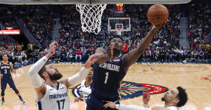 New Orleans Pelicans forward Zion Williamson (1) goes to the basket between Memphis Grizzlies center Jonas Valanciunas (17) and guard Dillon Brooks during the second half of an NBA basketball game in New Orleans, Friday, Jan. 31, 2020. The Pelicans won 139-111. (AP Photo/Gerald Herbert)