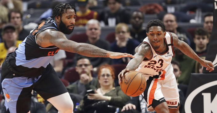 Cleveland Cavaliers' Andre Drummond, left, and Los Angeles Clippers' Lou Williams battle for loose ball in the second half of an NBA basketball game, Sunday, Feb. 9, 2020, in Cleveland. The Clippers won 133-92. (AP Photo/Tony Dejak)
