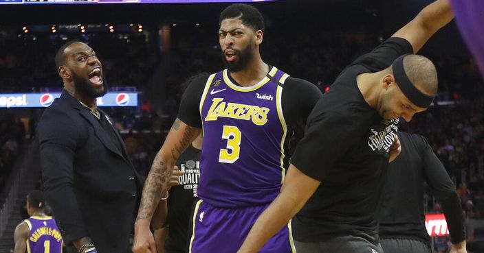 Los Angeles Lakers' LeBron James, left, celebrates with Anthony Davis (3) and Jared Dudley during the second half of an NBA basketball game against the Golden State Warriors in San Francisco, Thursday, Feb. 27, 2020. (AP Photo/Jeff Chiu)