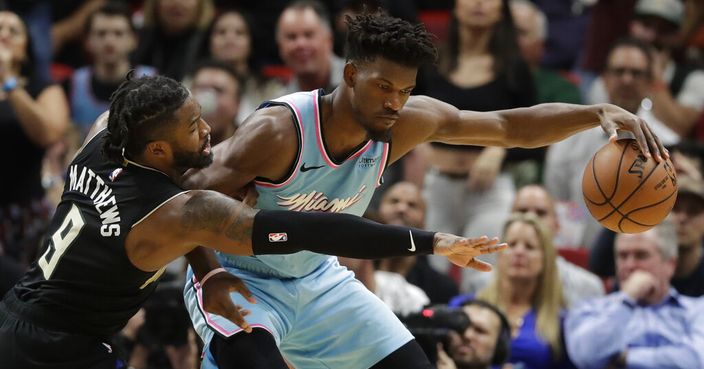 Milwaukee Bucks guard Wesley Matthews (9) attempts to steal the ball from Miami Heat forward Jimmy Butler during the second half of an NBA basketball game, Monday, March 2, 2020, in Miami. (AP Photo/Wilfredo Lee)