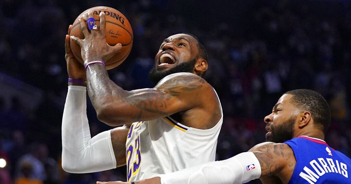Los Angeles Lakers forward LeBron James, left, shoots as Los Angeles Clippers forward Marcus Morris Sr. defends during the second half of an NBA basketball game Sunday, March 8, 2020, in Los Angeles. The Lakers won 112-103. (AP Photo/Mark J. Terrill)