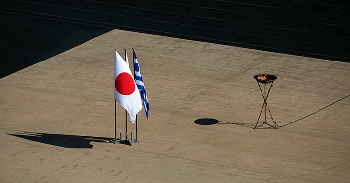 The Japanese flag flies next to an altar with the Olympic Flame of the Tokyo 2020 Olympic Games, inside the Panathenian stadium, in Athens, Sunday, March 15, 2020. The Panathenian Stadium will be closed to the spectators on Thursday, March 19 during the handover ceremony of the Olympic flame for the Tokyo 2020 Olympic Games as a precaution against the spread of the coronavirus. The vast majority of people recover from the new coronavirus. According to the World Health Organization, most people recover in about two to six weeks, depending on the severity of the illness. (AP Photo/Yorgos Karahalis)