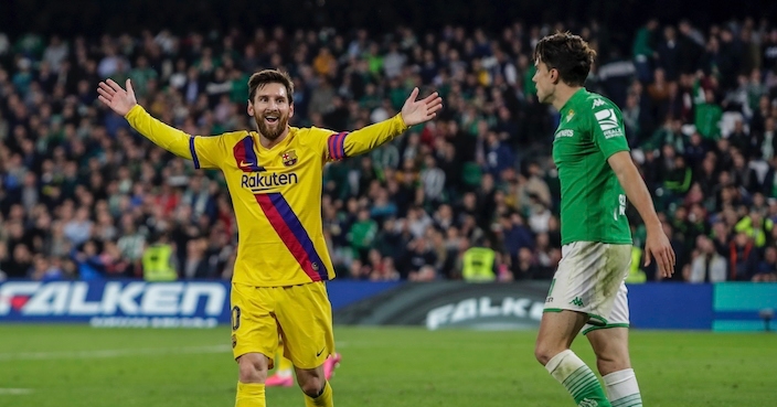Barcelona's Lionel Messi, left, gestures in front Betis' Marc Bartra during La Liga soccer match between Betis and Barcelona at the Benito Villamarin stadium in Seville, Spain, Sunday, Feb. 9, 2020. (AP Photo/Miguel Morenatti)