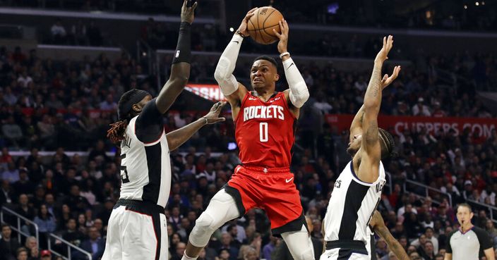 Houston Rockets' Russell Westbrook (0) drives to the basket between Los Angeles Clippers' Montrezl Harrell, left, and Rodney McGruder during the second half of an NBA basketball game Thursday, Dec. 19, 2019, in Los Angeles. (AP Photo/Marcio Jose Sanchez)