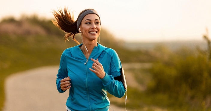 Dedicated athletic woman running in nature and dawn.